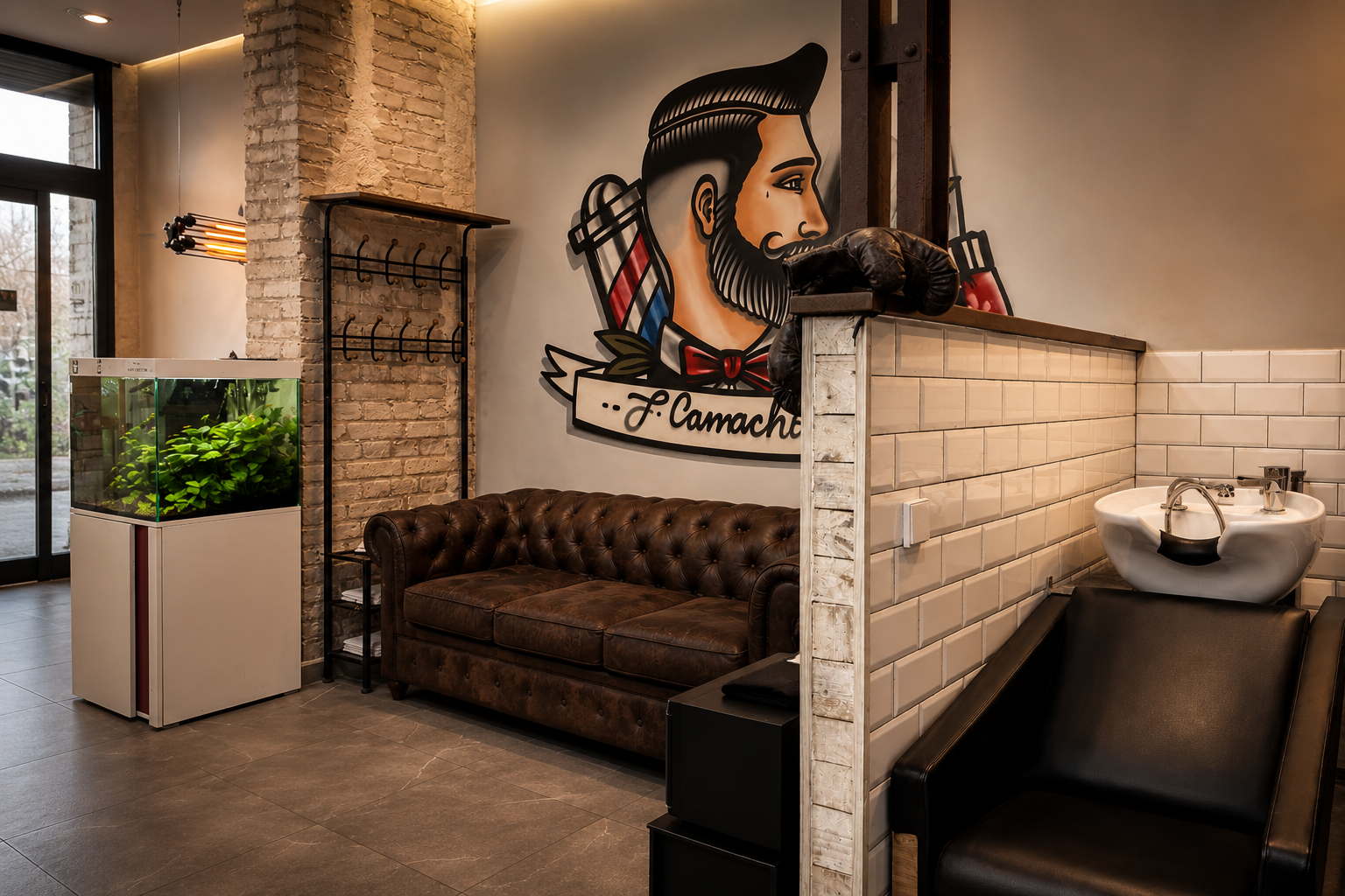 Entrada de la barbería con el mural de J. Camacho y sofá chesterfield